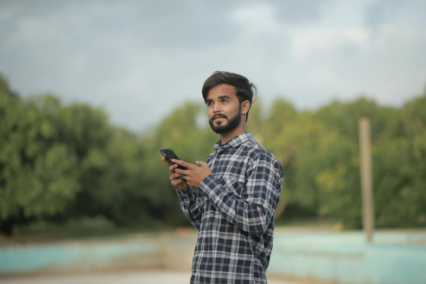 Portrait of a man using a smartphone outdoors in a
