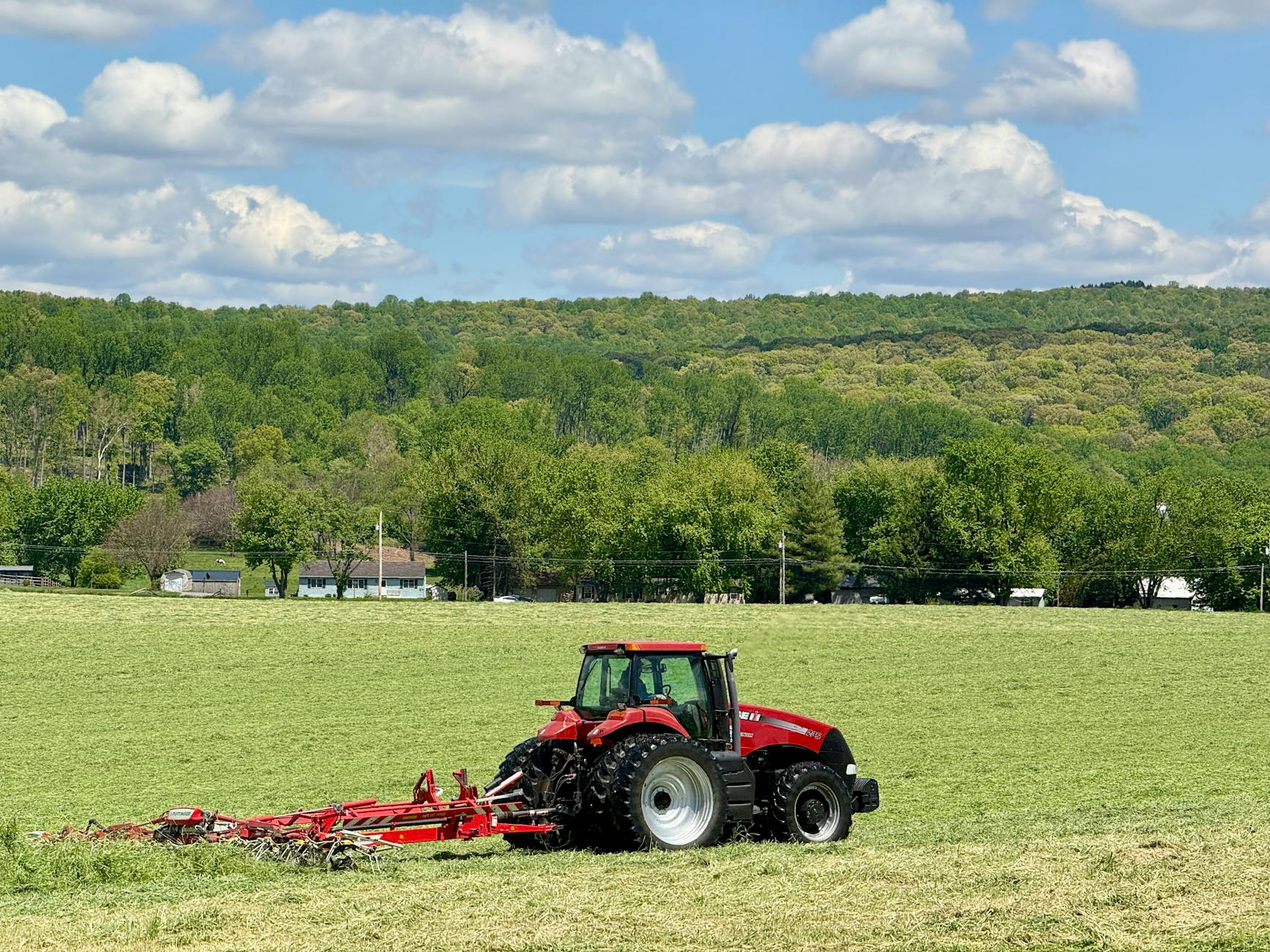 A red tractor working in a green field